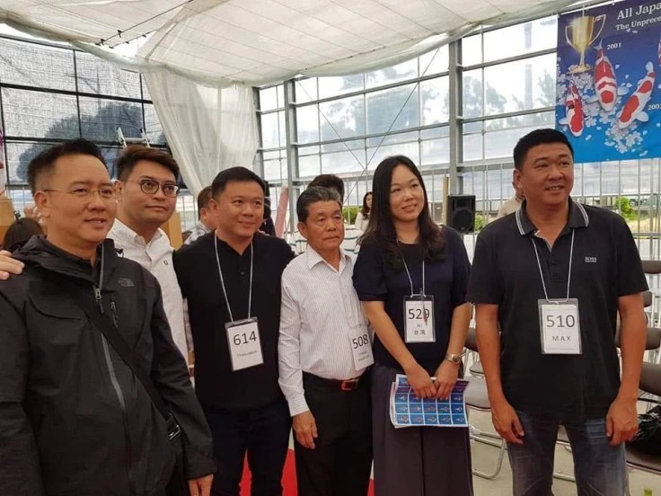 ผู้ร่วมงานถ่ายภาพหมู่ภายในสถานที่จัดงานปลาคาร์ฟ